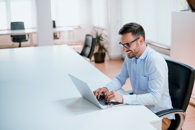 Imprenditore che lavora con un computer portatile in ufficio Foto Premium