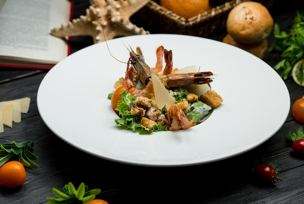 Insalata di granchio di frutti di mare con parmigiano fresco, cracker, verde all'interno di un piatto bianco Foto Gratuite