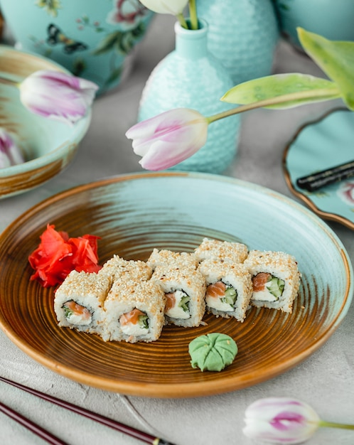 Involtini di sushi con salmone, crema di formaggio, cucuber ricoperti di sesamo Foto Gratuite