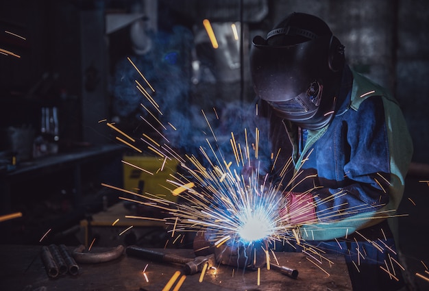 Lavoratore del lavoratore industriale presso la fabbrica di saldatura della struttura in acciaio Foto Premium
