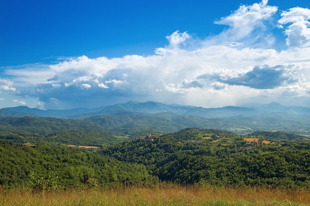 Le langhe sono una zona collinare nella provincia di cuneo in piemonte, nel nord italia. vista sulla valle dopo una tempesta. enormi nuvole bianche su un cielo blu. Foto Premium