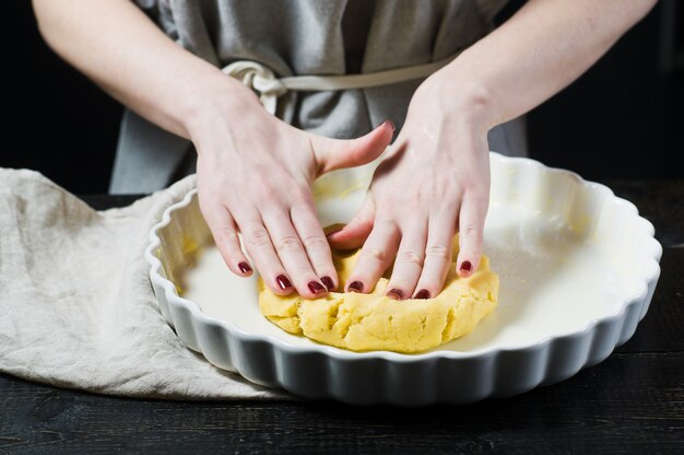 Lo chef stende l'impasto in una pirofila, cucinando Foto Premium