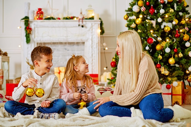 Immagini Di Natale Con Bambini.Mamma Con Bambini All Albero Di Natale Con Regali Congratularsi Con L Altro Buon Natale Foto Premium