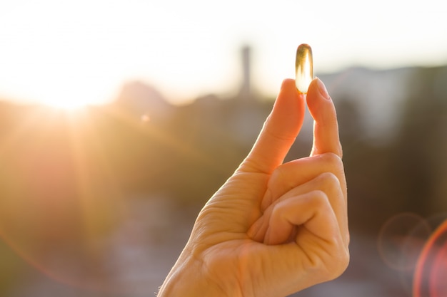 Mano di una donna con olio di pesce omega-3 capsule Foto Premium