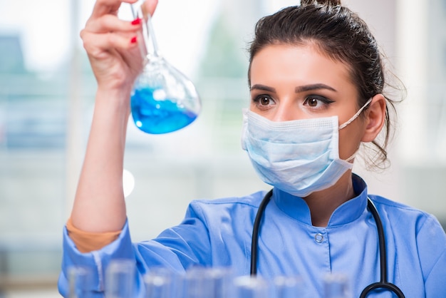 Medico della donna che effettua le prove chimiche in laboratorio Foto Premium