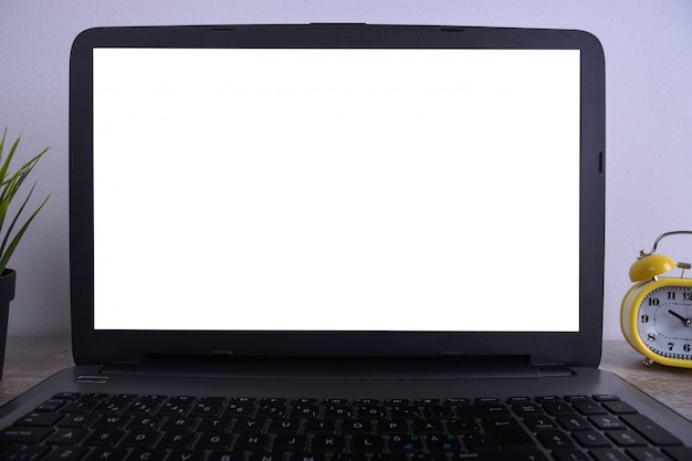 Modello bianco moderno della tavola della scrivania, spazio di lavoro con il computer portatile con lo schermo bianco per voi testo o immagine, erba verde, tazza di caffè e una pila di carte sul fondo bianco della roccia. Foto Premium