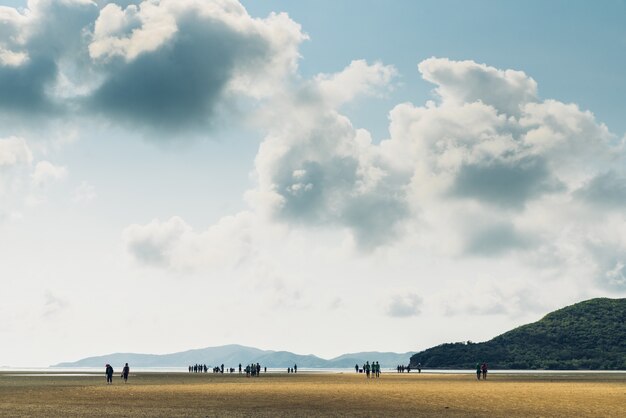 Paesaggio di bassa marea con la montagna verde, cielo della nuvola con la gente nel fondo alla baia di prong di toong in chon buri, distretto di sattahip, tailandia. Foto Premium