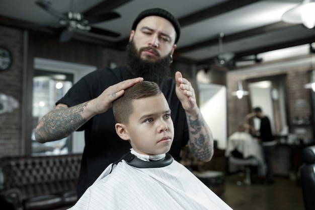 Parrucchiere che taglia i capelli del ragazzino | Foto Gratis