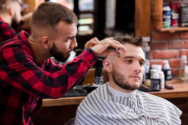 Parrucchiere prendersi cura dei capelli di un cliente Foto Gratuite