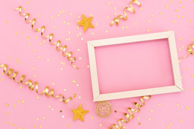 Photo frame mock up con spazio per il testo, coriandoli oro paillettes su sfondo rosa. Foto Premium