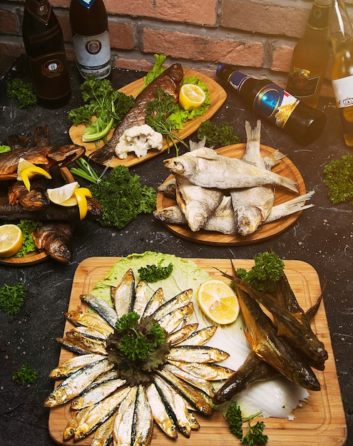 Piatto di pesce che cucina con vari ingredienti e tipi di pesce. branzino crudo con limone, aglio, erbe e spezie sul tagliere. cibo sano o concetto di nutrizione dieta. Foto Gratuite