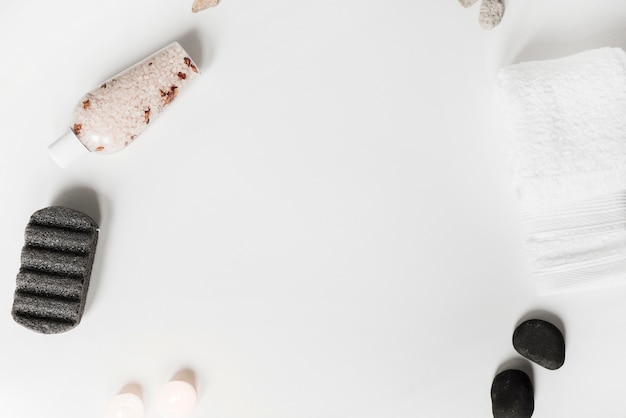 Pietra pomice; sale alle erbe; pietra termale; candele e asciugamano su sfondo bianco Foto Gratuite