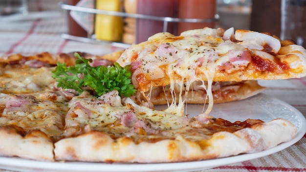 Pranzo della famiglia che mangia la ricetta del formaggio del prosciutto della pizza Foto Gratuite