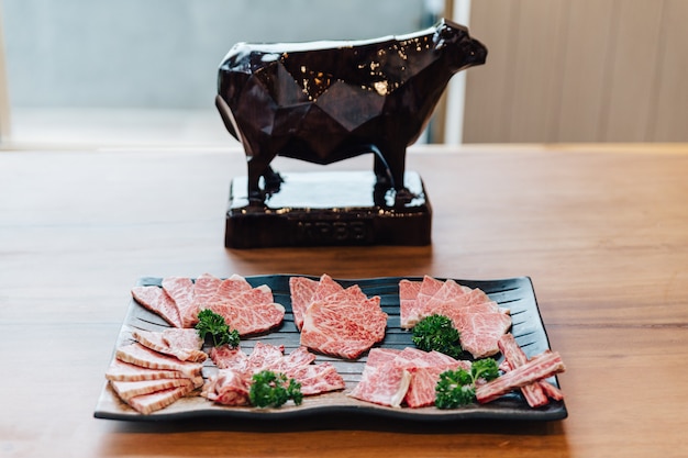 Premium rare affetta molte parti di manzo wagyu a5 con texture marmorizzata su lastra di pietra. Foto Premium