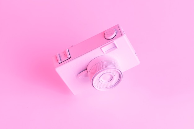 Primo piano della vecchia macchina fotografica dipinta contro il contesto rosa Foto Gratuite