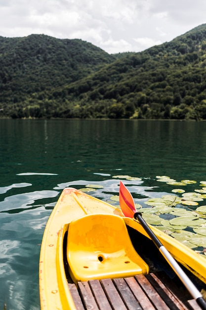 Primo piano di una canoa vuota sul lago vicino alla montagna Foto Gratuite