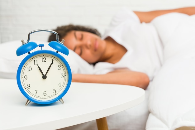 Primo piano di una giovane donna afro-americana che dorme sul letto Foto Premium