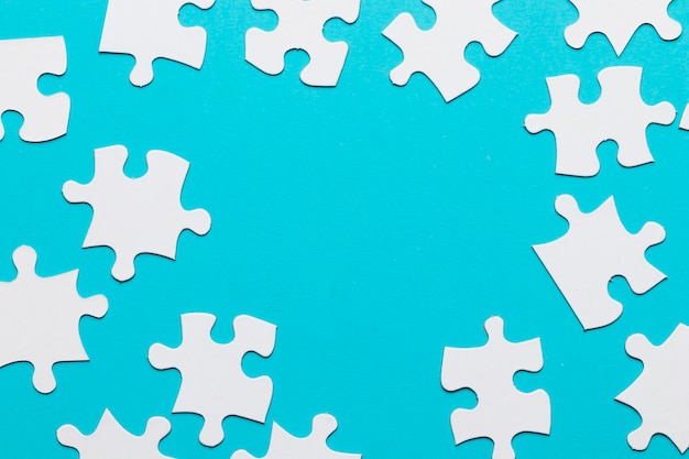 Puzzle bianchi sparsi su sfondo blu Foto Gratuite