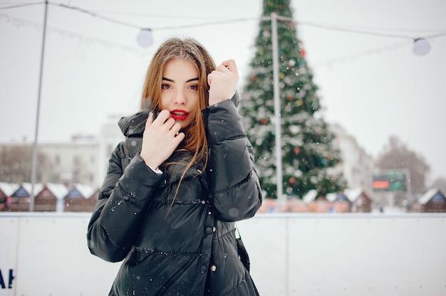 Ragazza in un maglione bianco che sta in un parco di inverno Foto Gratuite
