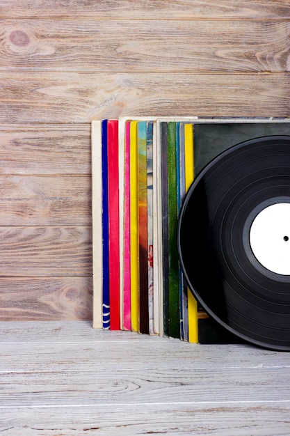 Retrò in stile immagine di una collezione di vecchi dischi in vinile con maniche su un legno. copyspace. Foto Premium