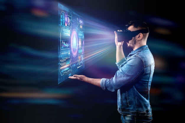 Ritratto di un uomo con gli occhiali della realtà virtuale, vr, interagisce con uno schermo virtuale. Foto Premium