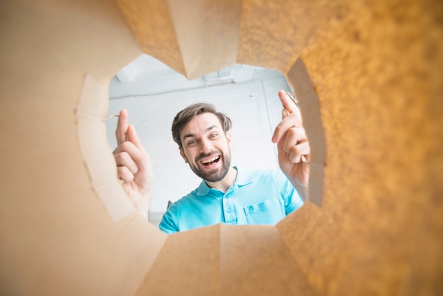 Ritratto di un uomo sorridente che guarda all'interno del sacchetto di carta Foto Gratuite