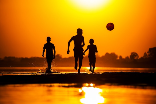 Sagoma Di Bambini Che Giocano A Calcio Sulla Spiaggia Foto