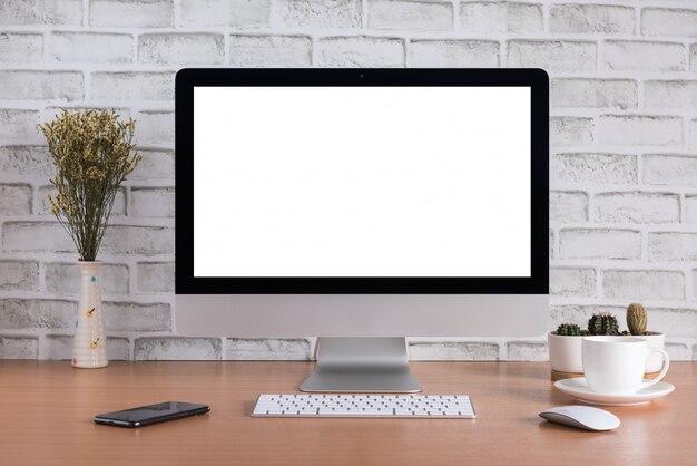 Schermo vuoto di tutto in un computer con fiori secchi, smart phone, tazza di caffè e vaso di cactus Foto Premium