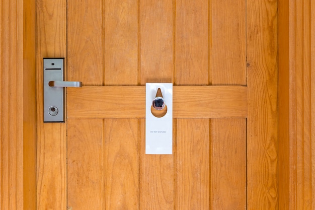 Si prega di non disturbare il segno sulla porta in legno chiusa della camera d'albergo Foto Premium