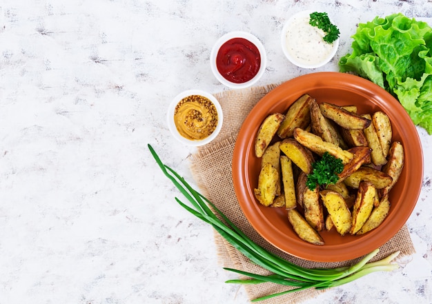 Spicchi di patate al forno con spezie. Foto Premium