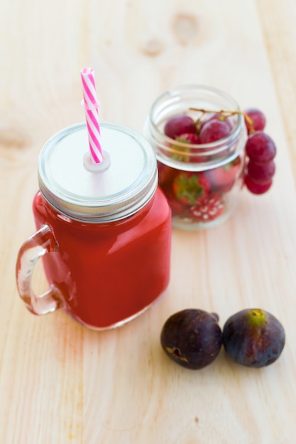 Succo di fragole, fichi e uva su fondo in legno. | Foto Gratis