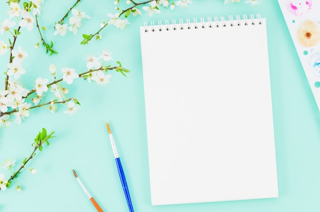 Taccuino di vista superiore con ramo di fiori Foto Gratuite