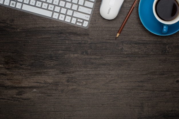 Tavolo con un computer portatile e una tazza di caffè blu Foto Gratuite
