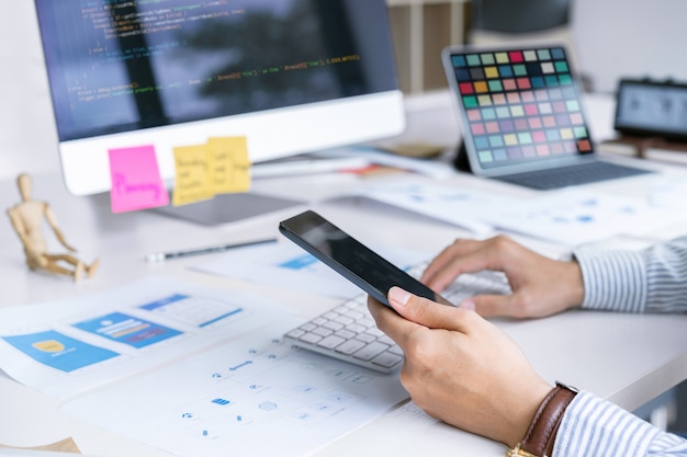 Team di designer front-end di startup creative che si concentrano sullo schermo del computer per la progettazione, la codifica, la programmazione di applicazioni mobili. Foto Premium