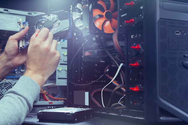 Tecnico che ripara un computer, il processo di sostituzione dei componenti sulla scheda madre. Foto Premium