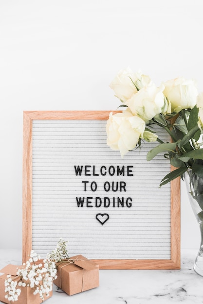 Telaio di benvenuto per il matrimonio con scatole regalo e rose su sfondo bianco Foto Gratuite