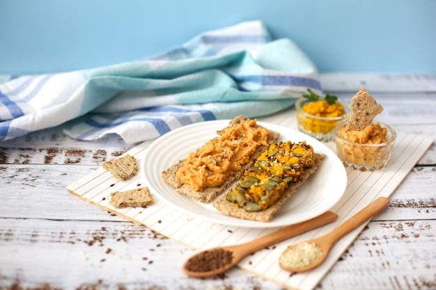 Toast Con Hummus Su Uno Sfondo Di Legno Bianco Pasta Di Ceci Sui Cracker Concetto Di Cibo Vegetariano Foto Premium