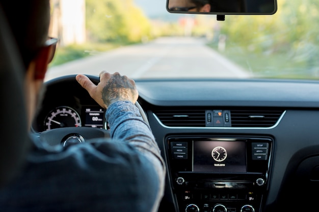 Uomo con gli occhiali da sole alla guida di automobili Foto Gratuite