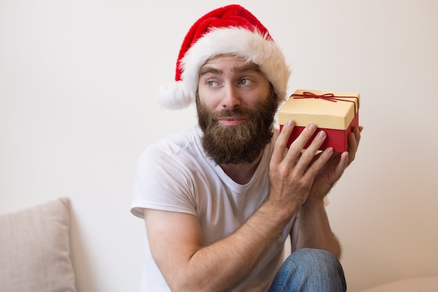 Che Cosa Significa Natale.Uomo Curioso Che Prova Ad Indovinare Che Cosa E Dentro La Scatola Di Regalo Di Natale Foto Gratis