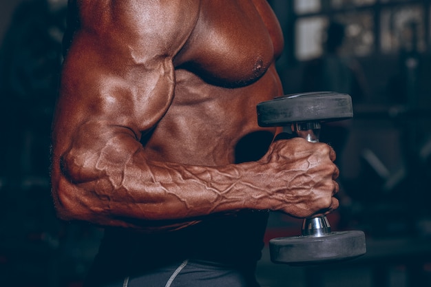 Le Persone Piu Muscolose Del Mondo.Uomo In Palestra Ragazzo Muscoloso Bodybuilder Che Fa Le Esercitazioni Con Il Dumbbell Persona Forte Con Mano Maschile Tesa Con Bilanciere Vene Tonalita Diario Moderna Foto Premium