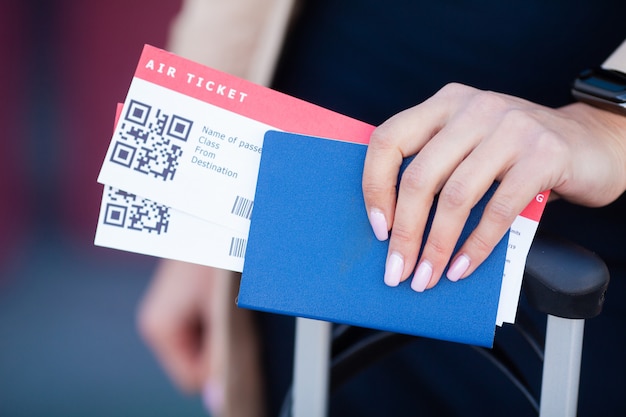 Viaggio. primo piano dei passaporti della holding della ragazza e della carta d'imbarco all'aeroporto Foto Premium
