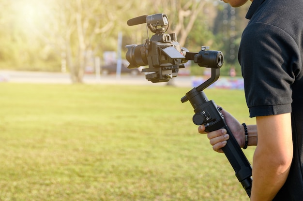 Videografo professionista con fotocamera su stabilizzatore cardanico per l'assunzione Foto Premium