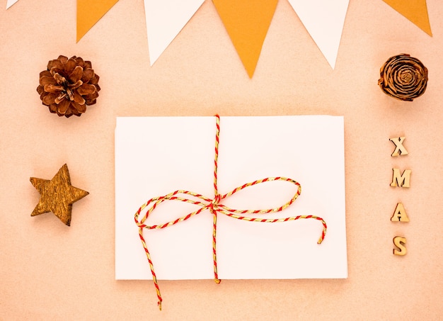 Vista dall'alto composizione di natale con regalo, carta bianca vuota, pigne, bandiere Foto Premium