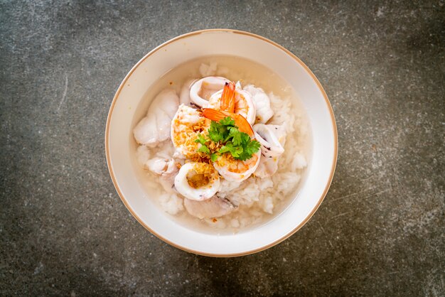 Zuppa di porridge o riso bollito con scodella di pesce ...