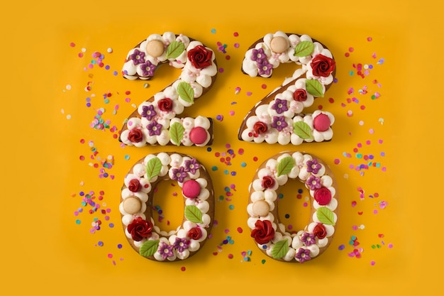 2020 bolos e ornamentos na superfície amarela Foto Premium
