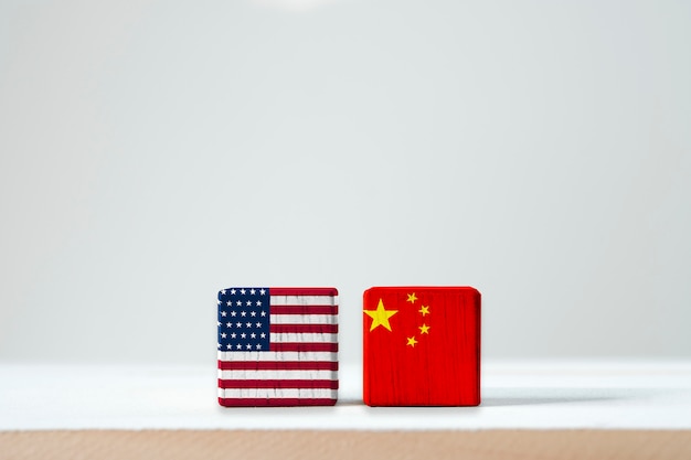 A bandeira dos eua e a bandeira de china imprimem a tela no cúbico de madeira. é símbolo da barreira do imposto da guerra do comércio da tarifa entre os estados unidos da américa e a china Foto Premium