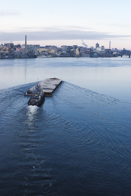 A barcaça flutuando no rio dnieper. paisagem da cidade de kiev no fundo. 17.11.2018 Foto Premium