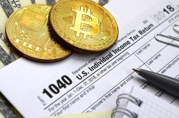 A caneta, bitcoins e notas de dólar é mentiras no formulário 1040 de imposto de renda individual nos eua. o tempo para pagar impostos Foto Premium