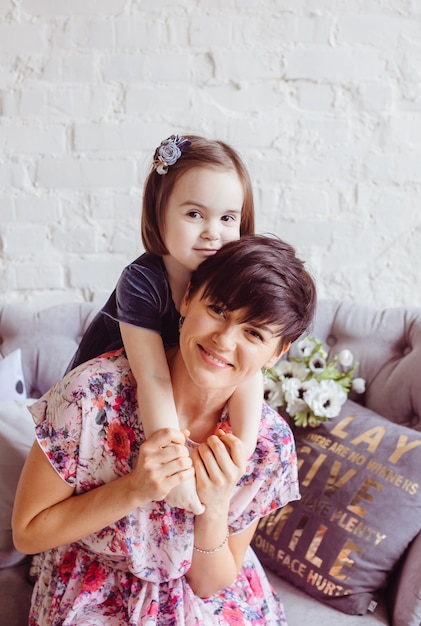A filha abraçando sua mãe no quarto Foto gratuita