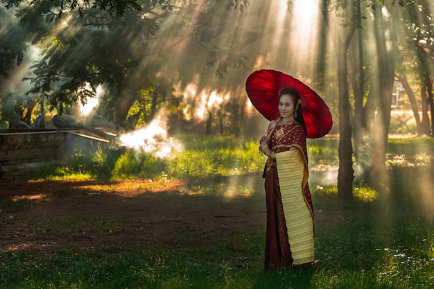 A menina tailandesa das mulheres bonitas que guarda a mão a festão do jasmim no traje tailandês tradicional com ayutthaya do templo é ouro da textura, cultura da identidade de tailândia. Foto Premium